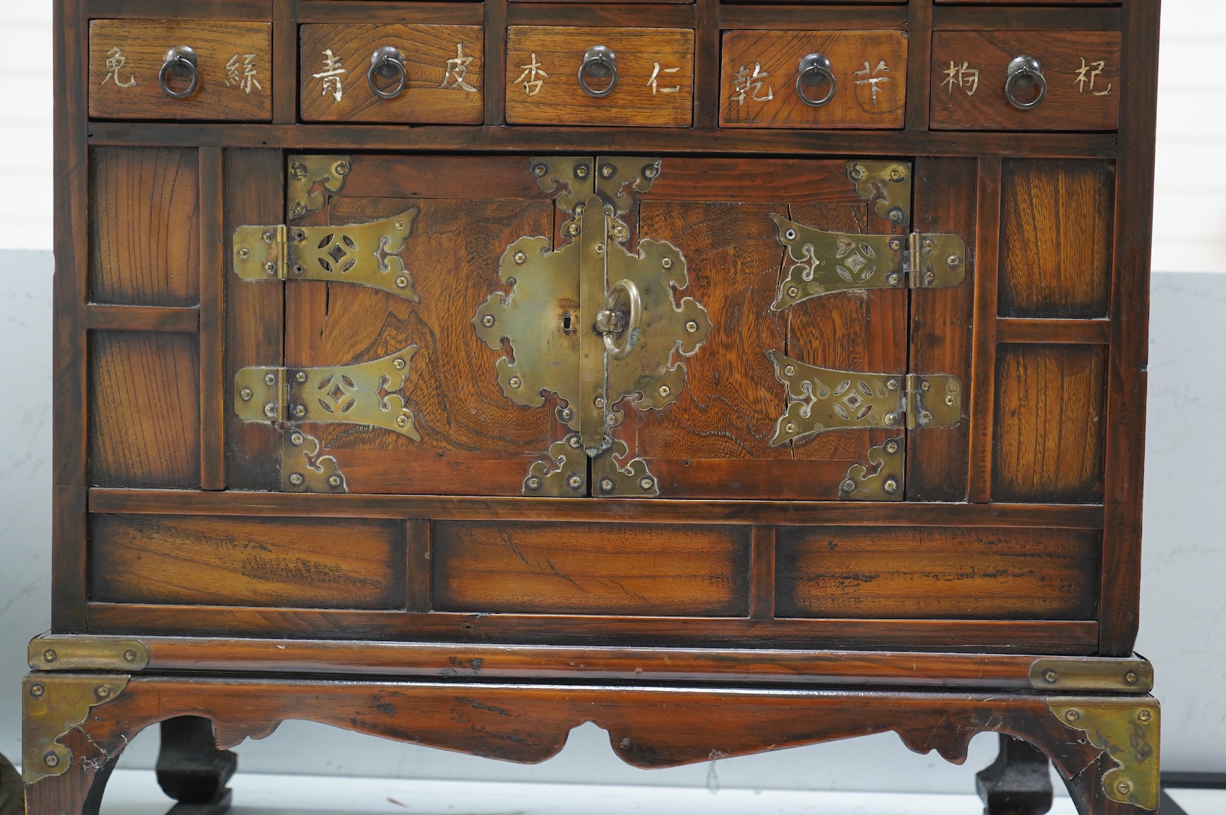 A Korean brass mounted chest with fitted drawers, decorated with calligraphy, 64cm high